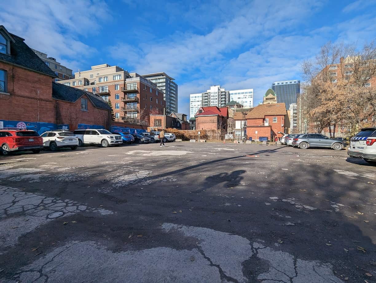 Vacant parking lot next to brick rental buildings in Ottawa, showing the land portion of a purchase that CCA cannot be claimed on